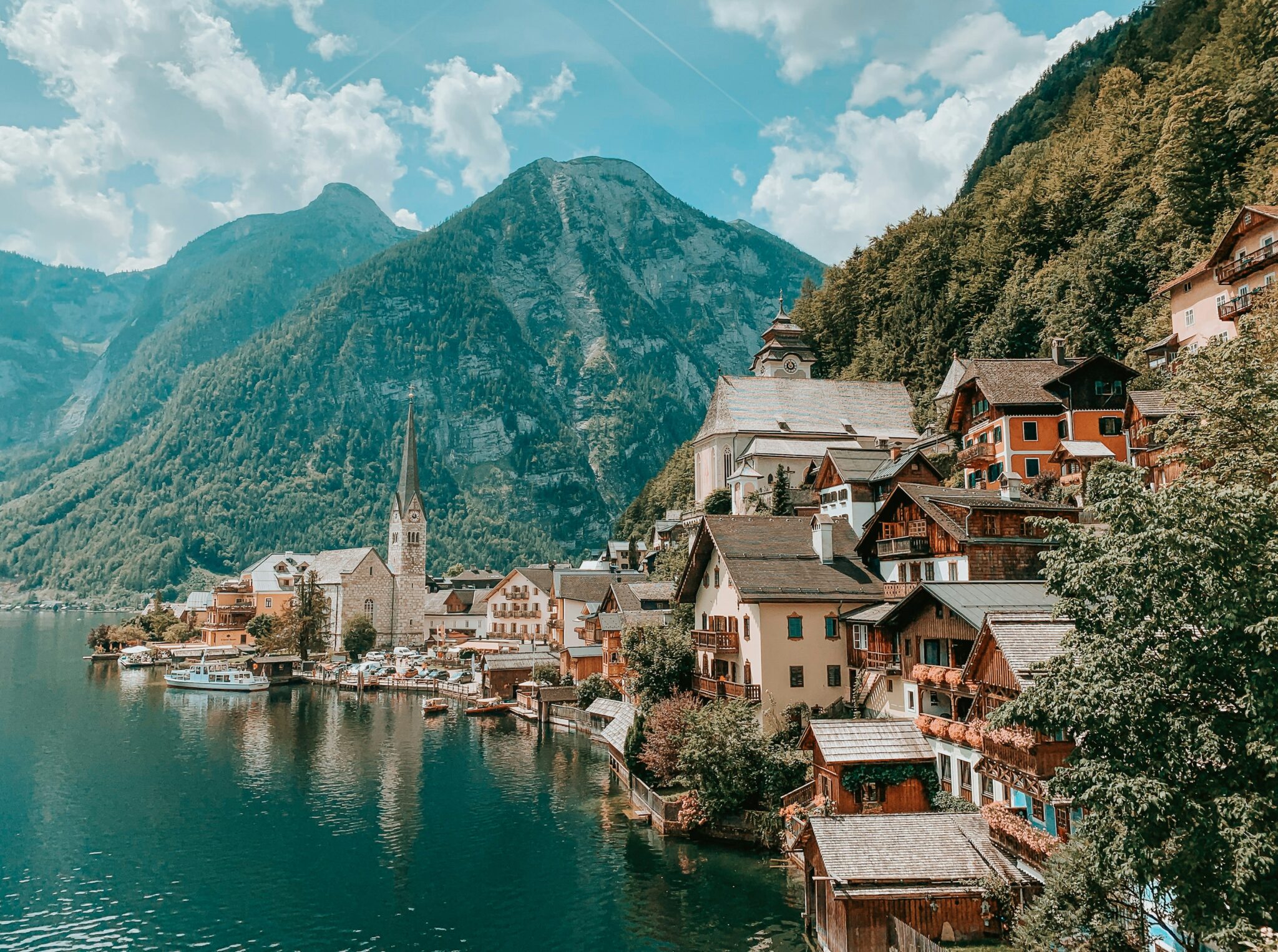 houses near body of water and mountain during daytime