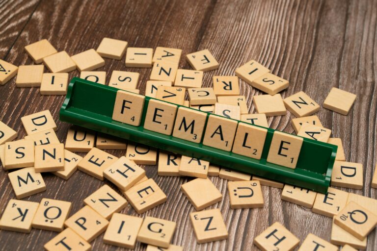 scrabble tiles spelling the word female on a wooden surface