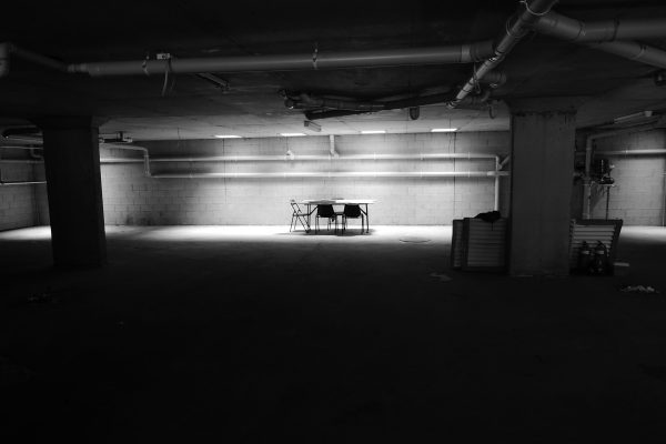 table with chairs near wall in a dark room