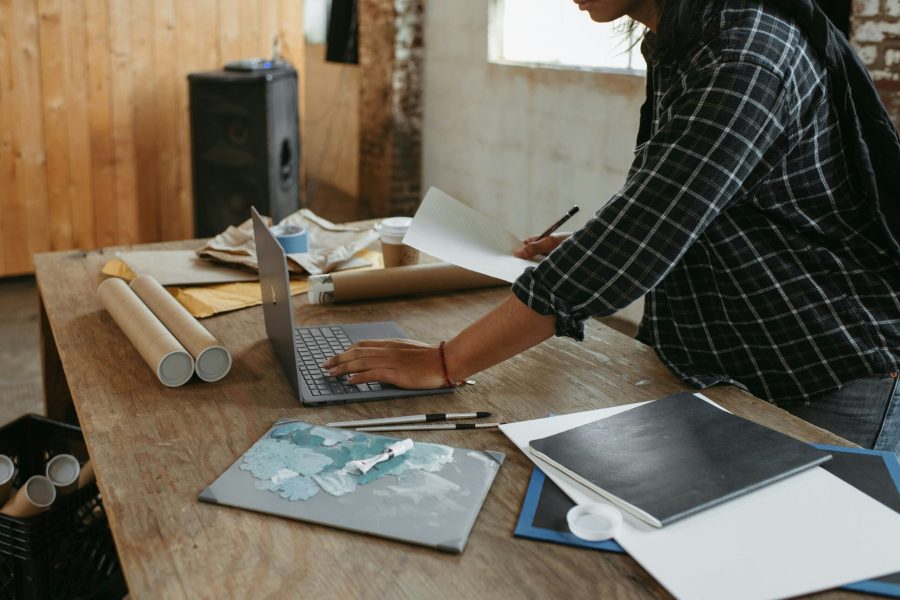 a woman sitting at a table working on a laptop